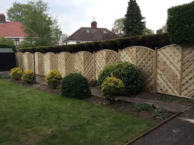Diamond-lattice topped fence panels along a garden border